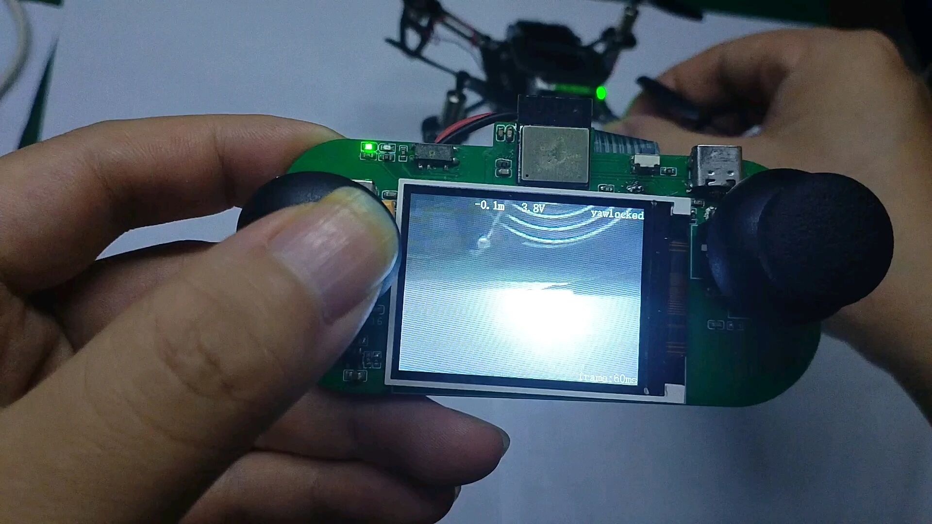 Handheld controller with a green PCB, small display and yaw-lock status readout